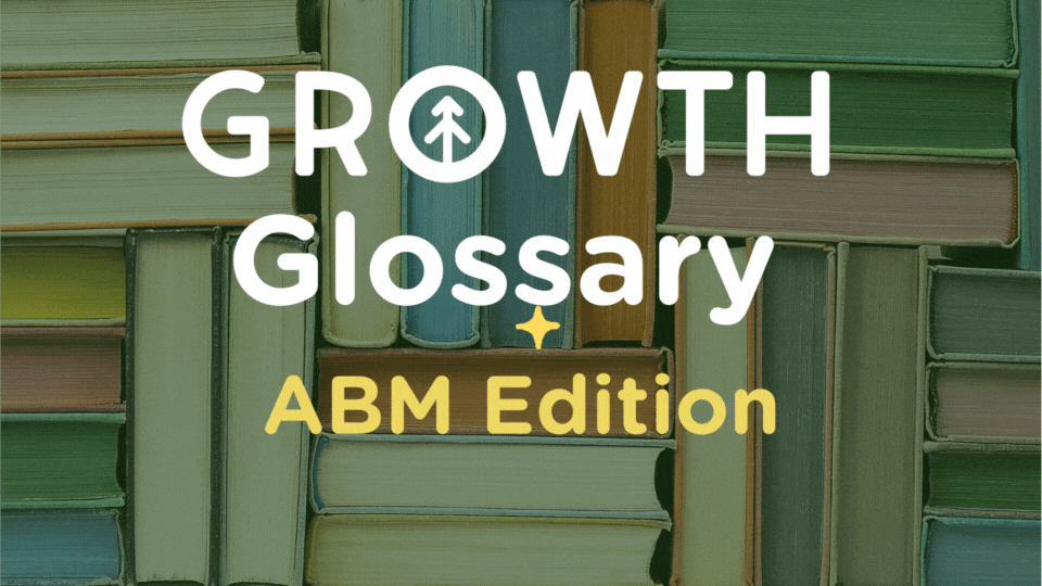A closeup a stack of colorful books from the side with the title of the blog article "Growth Glossary: ABM Edition" from Growth Marketing Firm. 