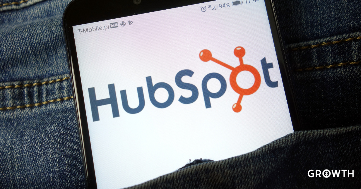 A mobile phone with the HubSpot logo on the screen rests in the back pocket of someone's jeans.