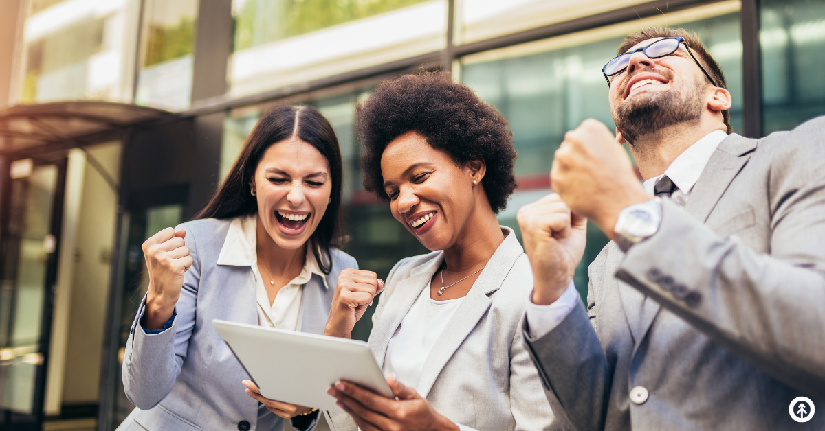 Three business people celebrating good news that's just been communicated through a mobile device. 