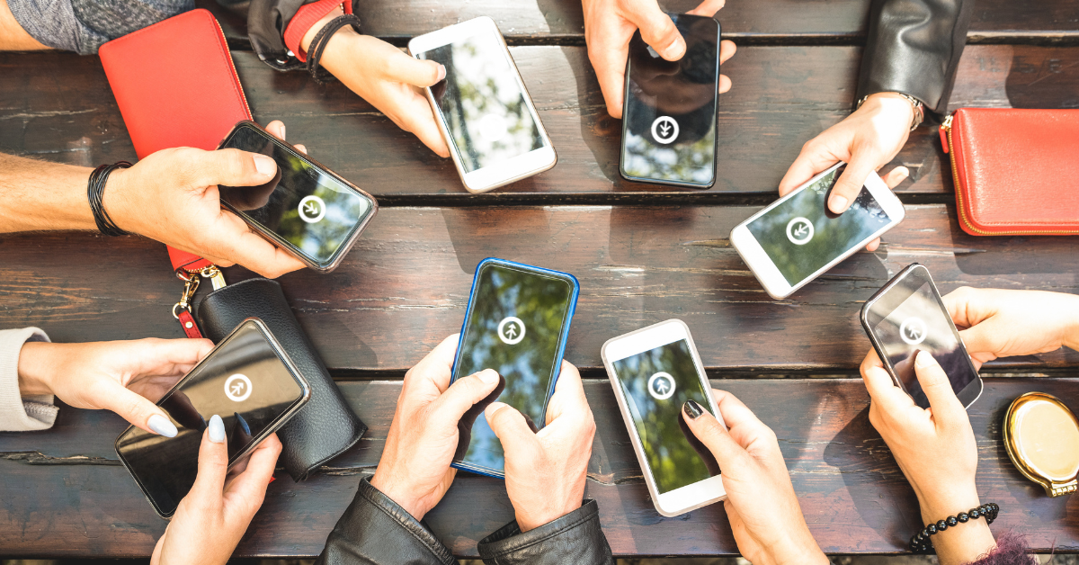 A group of people holding their mobile devices together showing the logo of Growth Marketing Firm. 