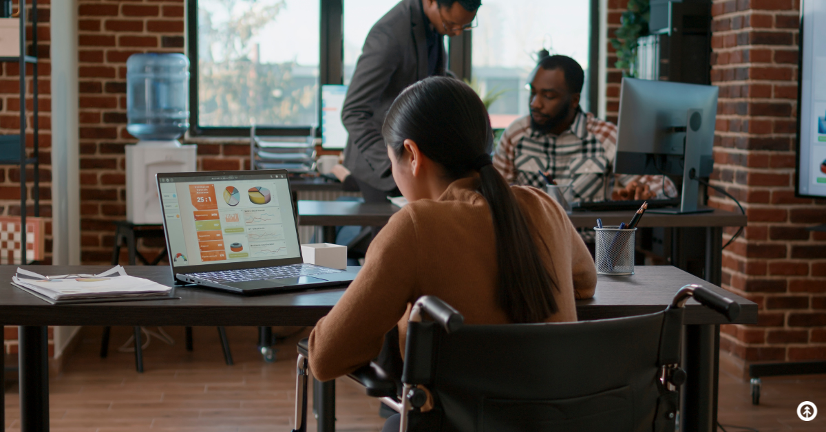 A person reading data on a laptop computer in an office setting.