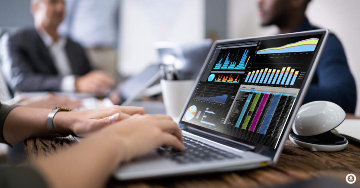 A closeup of a laptop screen with a variety of data points and KPIs are shown with charts and graphs. 