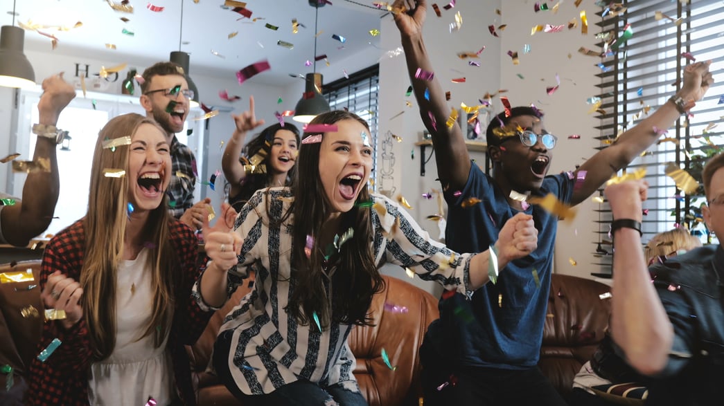 A group of young people celebrating with confetti