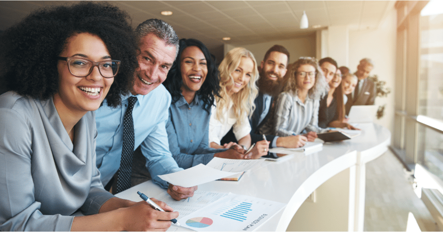 A diverse team of professionals in line at a table.